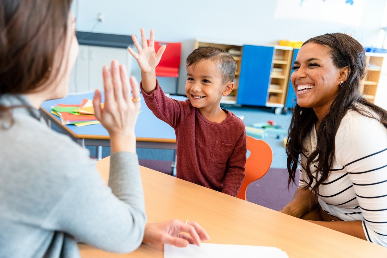 preschool teacher gives boy high five
